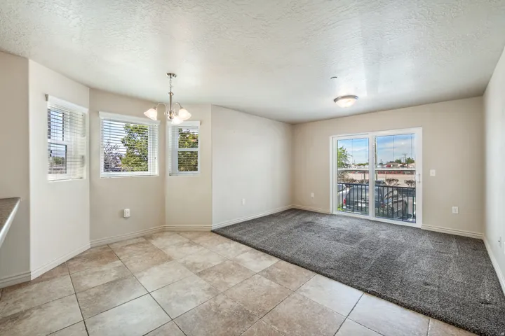 Recessed lighting, sliding glass door, textured carpeting, tiled flooring, pendant light fixture