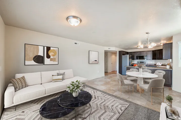 Open-concept living area with light-toned walls, tile flooring, dark wood-finish cabinetry, stainless steel appliances, and ceiling-mounted lighting fixtures. *Virtually staged photo.