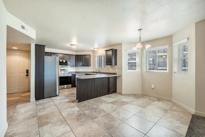 Kitchen featuring dark wood-finish cabinetry, stainless steel appliances, and a breakfast bar