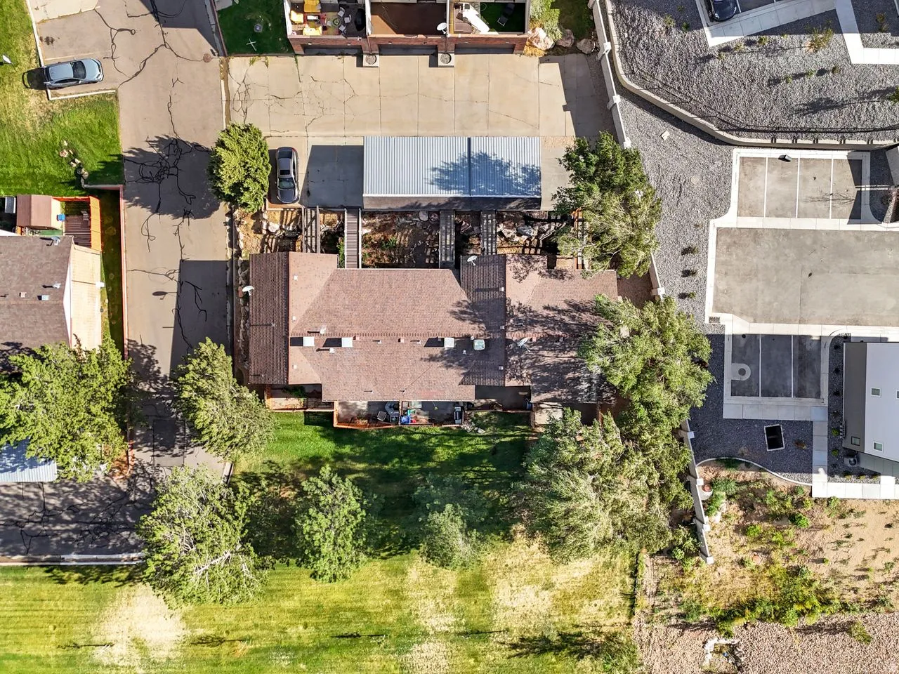 Brown shingle roof, mature trees, and a grassy area surrounding the property