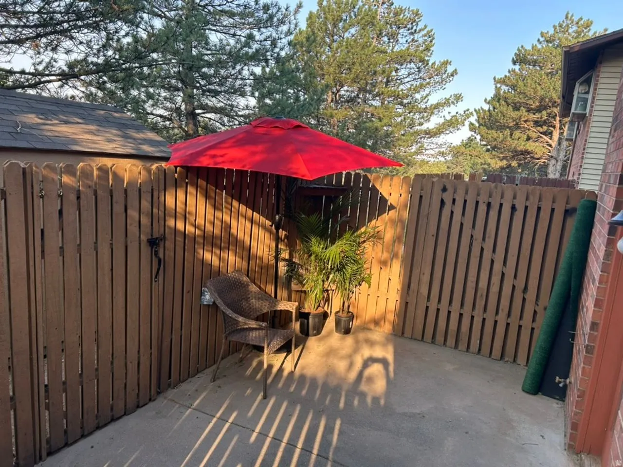 Private outdoor patio with a concrete surface, enclosed by a wood privacy fence