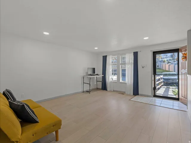 Recessed lighting, wood-finish flooring, multiple windows, a transom window, and a tiled entryway