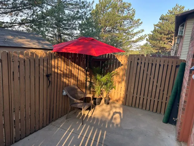 Private outdoor patio with a concrete surface, enclosed by a wood privacy fence
