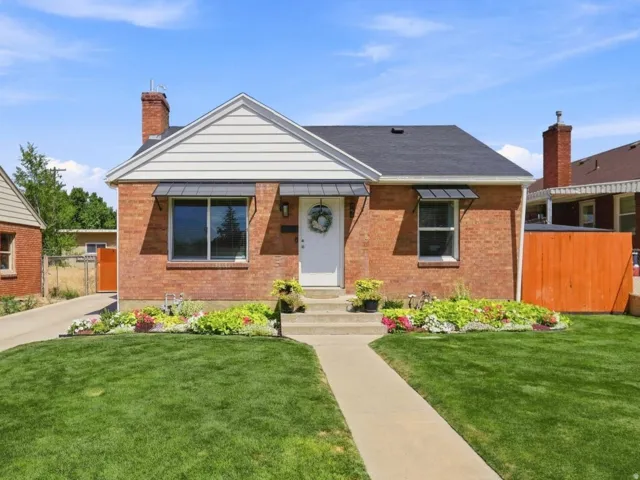 Brick exterior with white siding accents and a contrasting dark roof