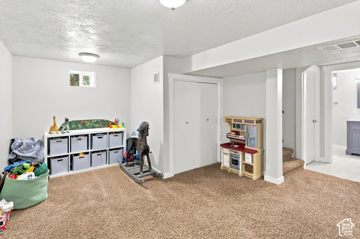 Carpeted floor, recessed window, white walls, built-in closet, and overhead lighting