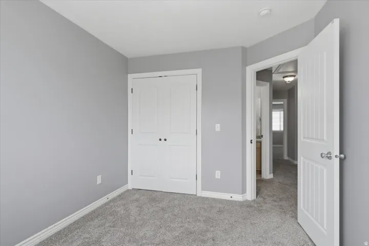 Gray carpeting, white baseboards, and light gray wall paint