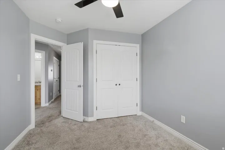 Recessed ceiling light with a ceiling fan, light gray wall paint, and gray carpet flooring