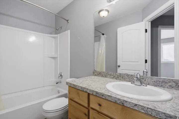 White tub and shower combination with built-in shelving