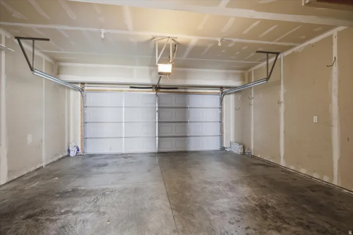 Two-car garage featuring a concrete floor, two individual garage doors, and overhead lighting