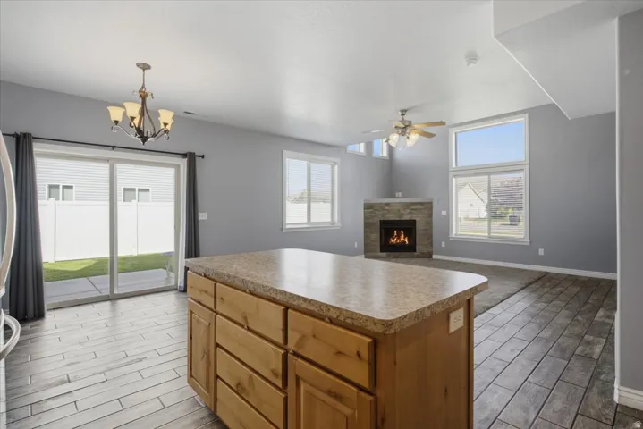 Kitchen island with a laminate countertop, wood-finish flooring, and a sliding glass door to the exterior