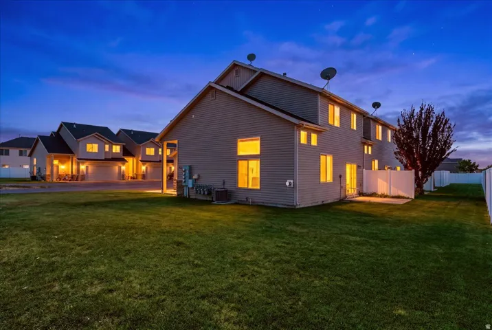 Expansive green lawn with a privacy fence and concrete patio