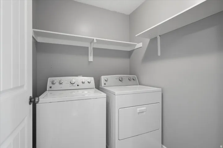 White paneled door with a satin nickel doorknob, two white wall-mounted shelves, and a textured ceiling