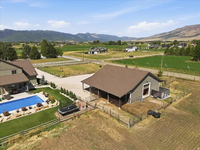 Expansive rural property featuring a modern barn-style residence with dark metal roof, situated on manicured grounds with mature landscaping