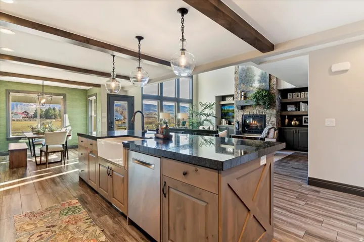 Kitchen island with granite countertop, white farmhouse sink, and integrated dishwasher