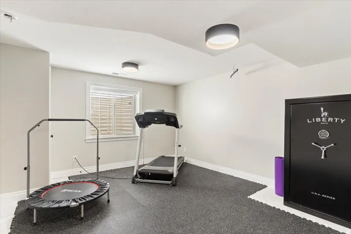 Recessed window with blinds, baseboard trim, and ceiling-mounted light fixtures illuminate the space