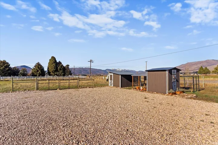 Gravel driveway and two outbuildings with metal roofs