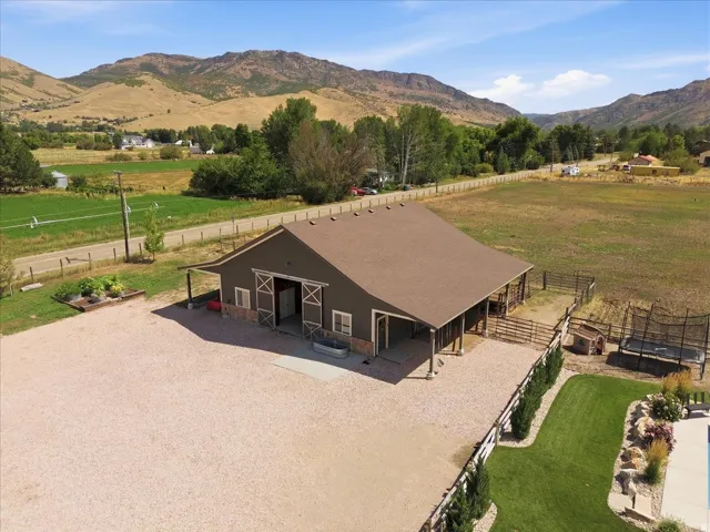 Large barn structure with a brown gambrel roof, stone-finish accents, and sliding barn doors
