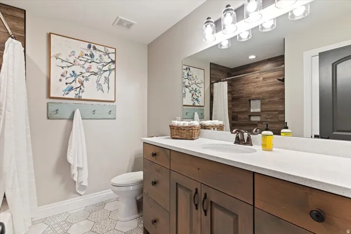 Wood-finish vanity with dual sinks and white countertop