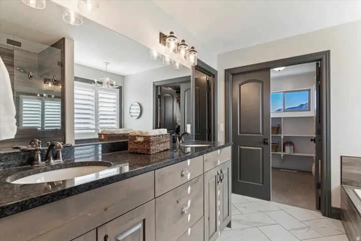 Double vanity with dark granite countertops and undermount sinks