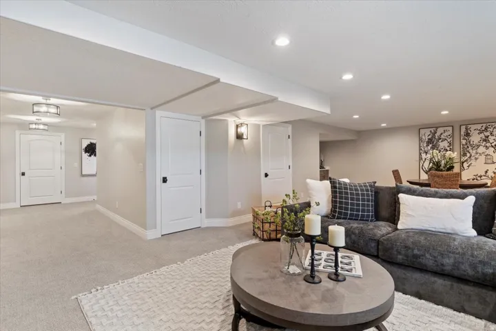 Recessed lighting, neutral wall tones, white paneled doors, wall-mounted light fixtures, and carpeting