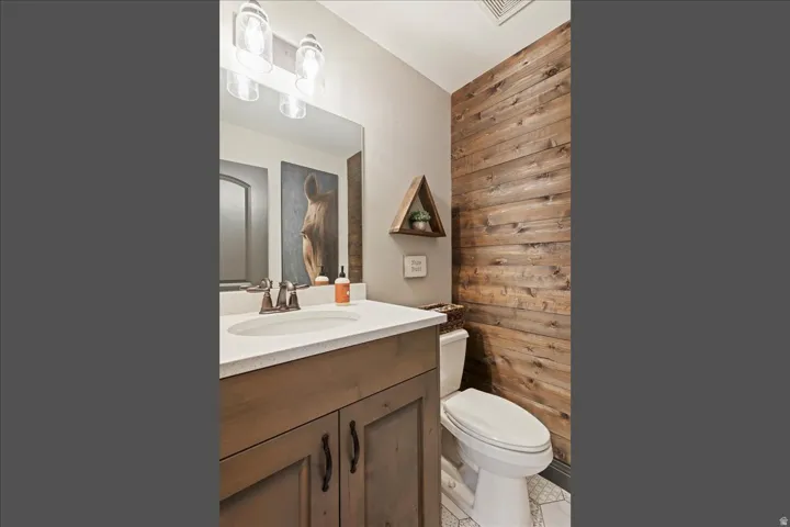 Vanity with integrated sink, wood-finish cabinetry, and brushed nickel faucet