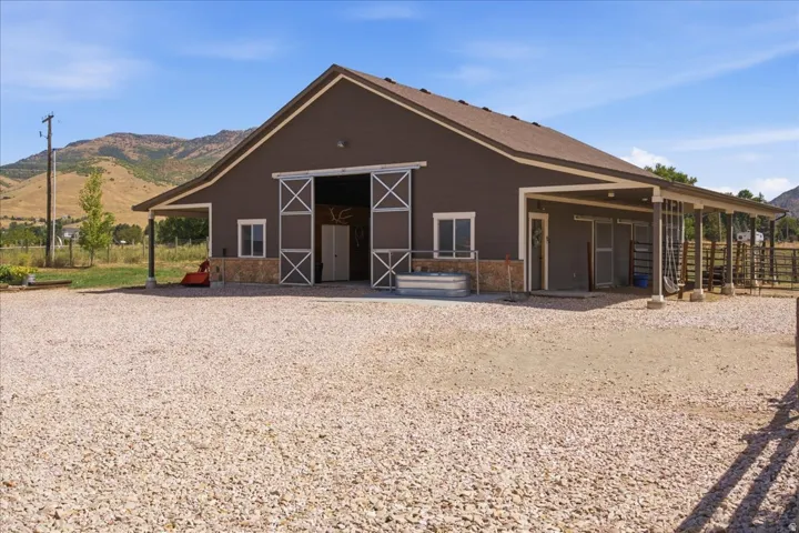 Barn-style structure featuring sliding barn doors and a covered porch