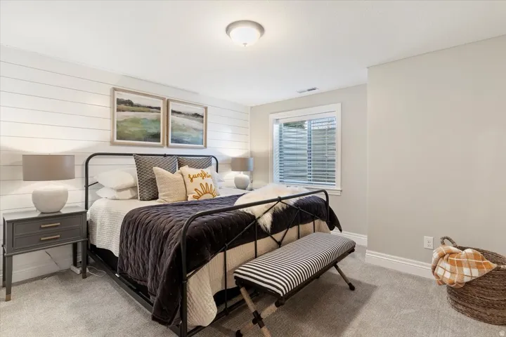 Shiplap accent wall, light gray carpeting, recessed window with blinds, overhead flush mount lighting, and white trim