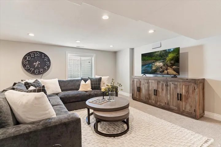 Recessed lighting, light-toned walls, and a built-in wood-finish media console