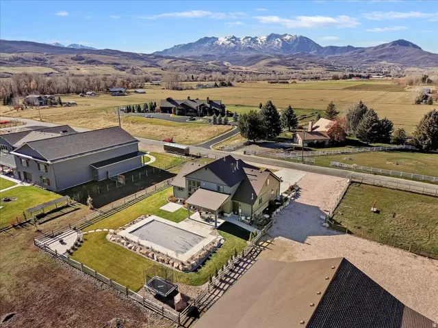 Expansive property featuring a covered swimming pool, paved patio, and a dedicated fire pit area