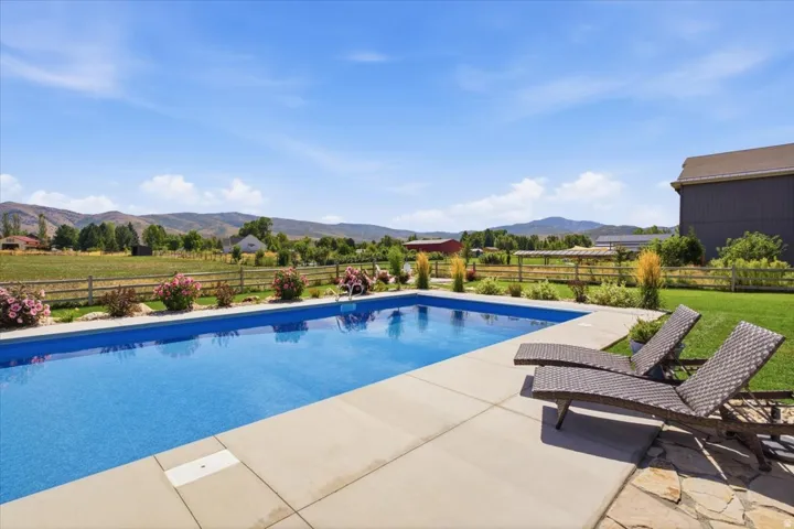 Rectangular inground pool with concrete surround and stone patio
