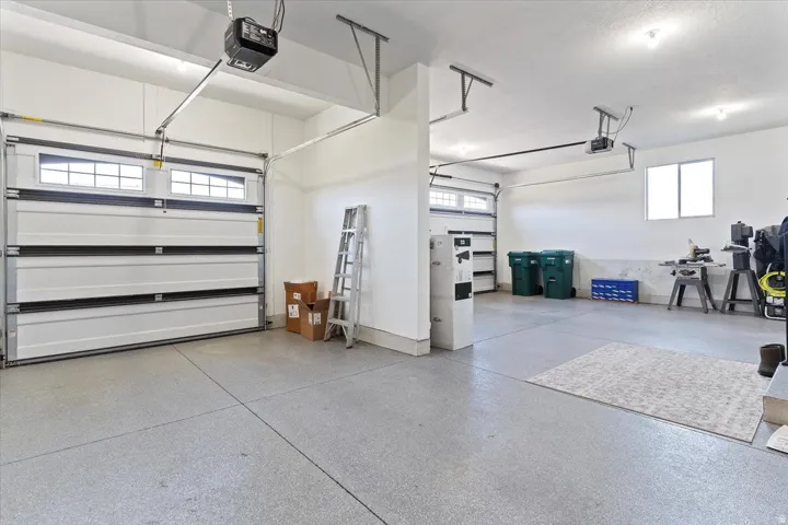 Spacious garage featuring two overhead doors with window inserts and an epoxy-coated concrete floor