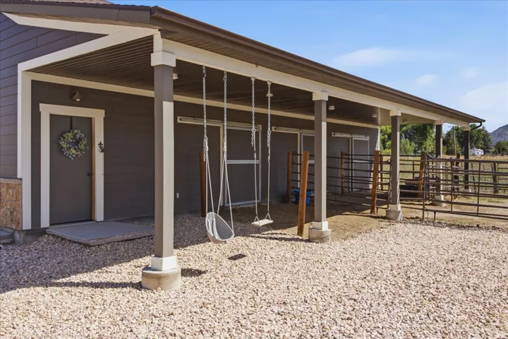 Covered patio with durable siding, gravel ground cover, and adjacent fencing