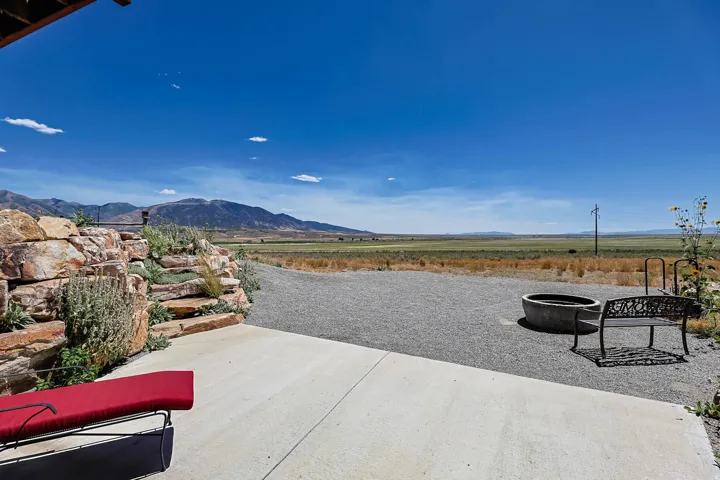 Concrete patio with a decorative rock wall and integrated landscaping