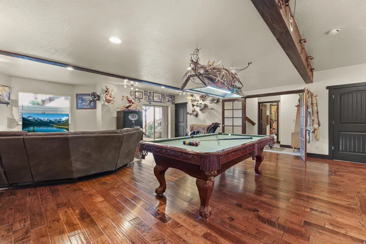 Hardwood flooring, recessed lighting, exposed ceiling beam, exterior access via glass-paned doors, and solid panel interior doors