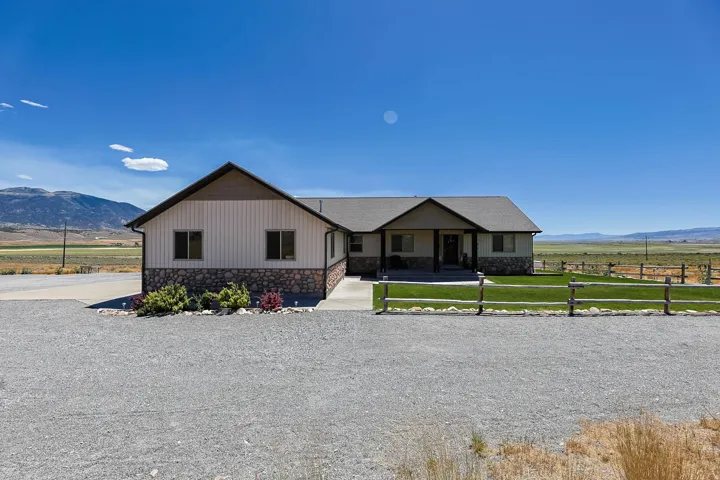 Ranch-style residence featuring a covered entry, stone and vertical siding exterior, and gabled roofline