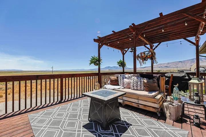 Wood-finish deck with a pergola, string lighting, and wood railing