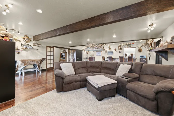 Recessed lighting, wood-finish flooring, exposed ceiling beam, track lighting, and French doors