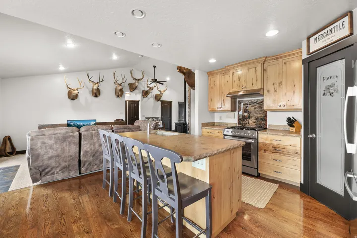 Wood-finish flooring, recessed lighting, vaulted ceilings, and a kitchen island with seating