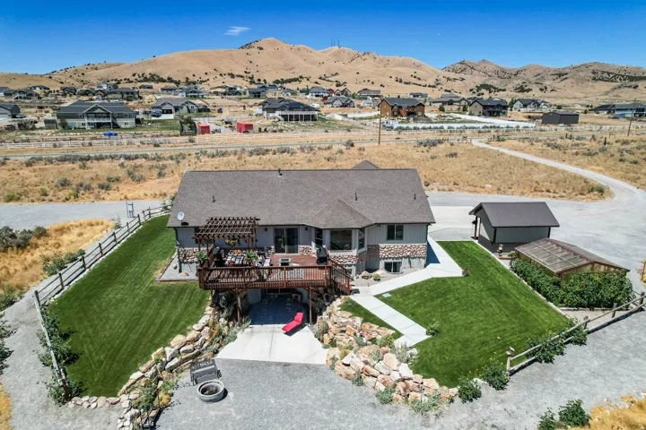 Expansive outdoor deck with a pergola, lower level patio, detached shed, and a greenhouse structure