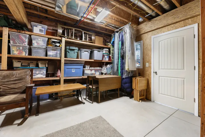 Concrete flooring, wood-paneled walls, built-in wooden shelving, and a paneled interior door