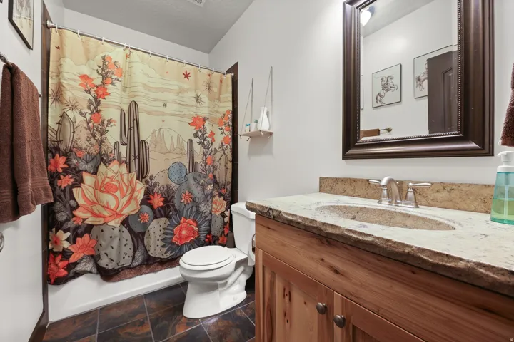 Vanity with a natural-edge countertop, undermount sink, and brushed nickel faucet