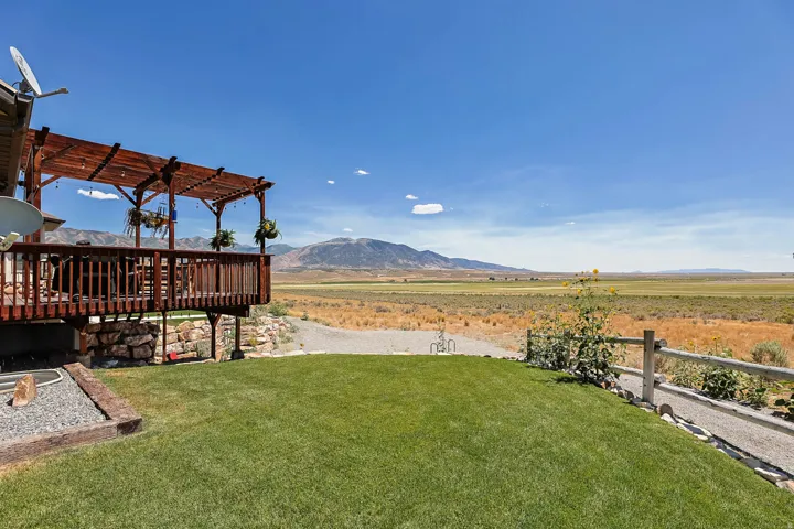 Expansive grassy lawn with a gravel pathway, leading to a wooden fence