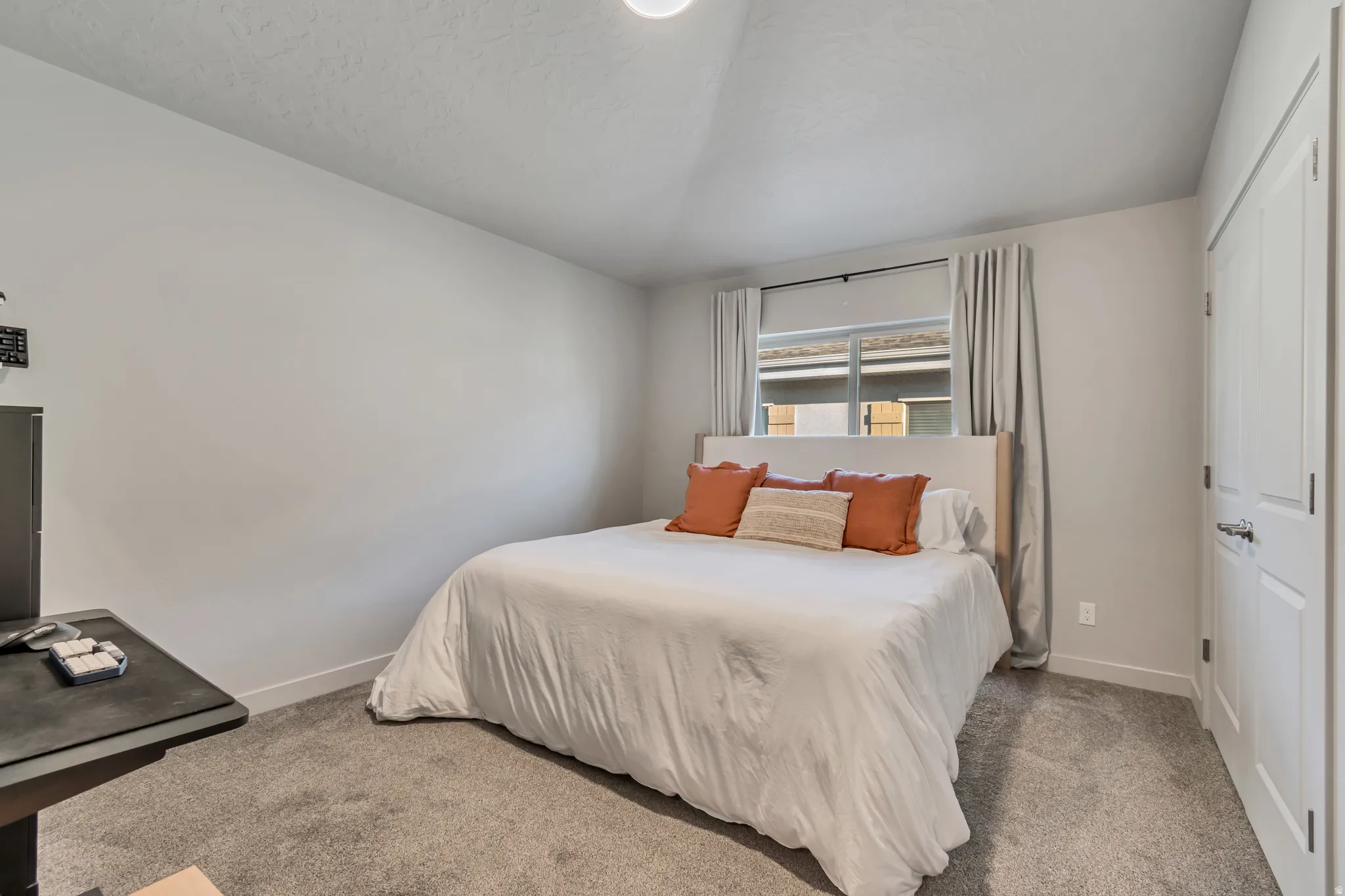 Neutral wall color, carpeted flooring, window with blinds, and a paneled door