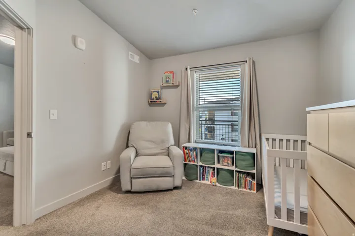 Carpeted room featuring a window with horizontal blinds, built-in shelving, and a neutral wall color