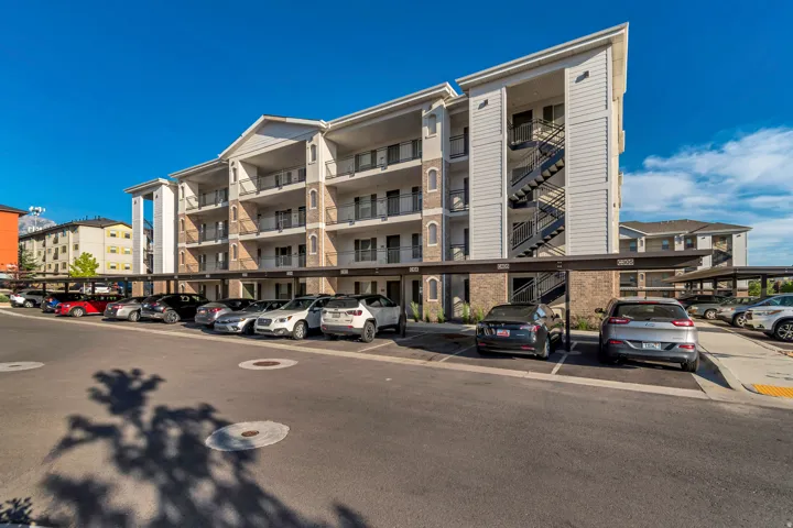 Multi-story building featuring balconies, covered parking structures, and exterior staircases