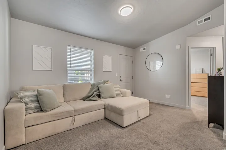 Neutral wall paint, ceiling-mounted light fixture, recessed lighting, wall-to-wall carpeting, and a white door with dark hardware