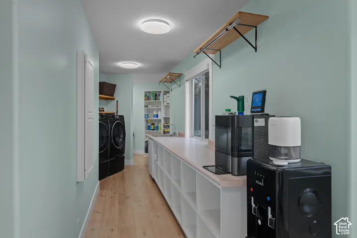 Built-in cabinetry with a light-toned countertop, wood-finish flooring, recessed lighting, and a window
