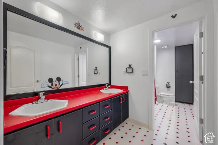 Dual vanity with a red countertop and black cabinetry