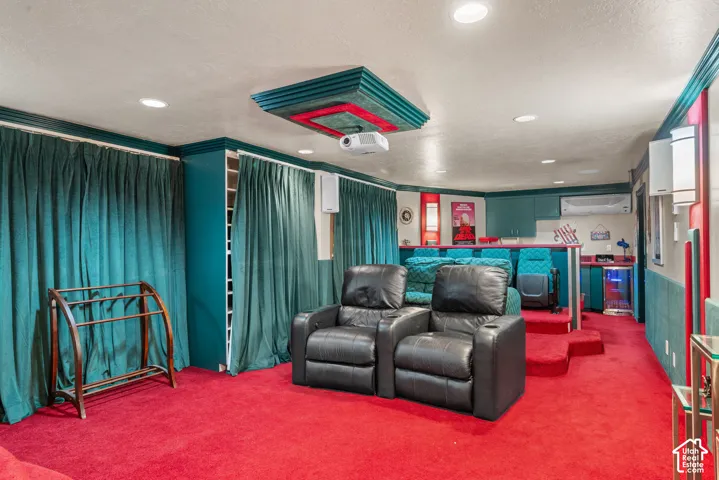 Dedicated theater space with tiered seating, recessed lighting, built-in cabinetry, and integrated projector