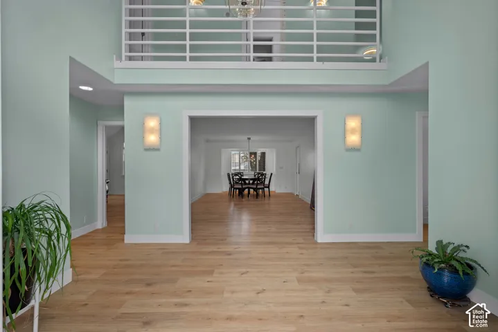 Two-story entry with wood-finish flooring, recessed lighting, and wall sconces
